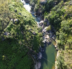 Vista aérea con dron del cañón de un río encajonado entre laderas de bosque.